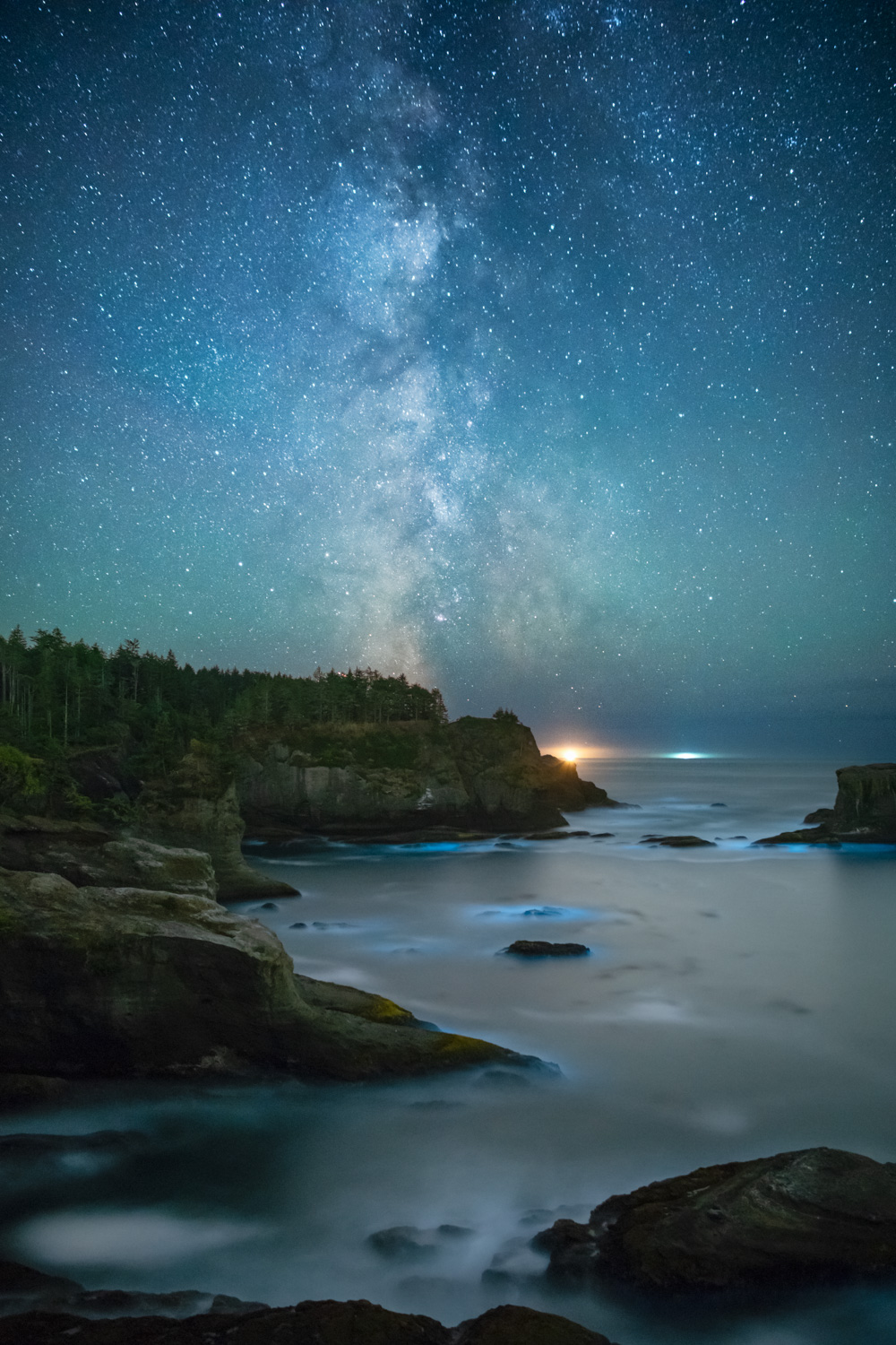 The Milky Way galaxy above Cape Flattery with bioluminescent plankton in the waters below.