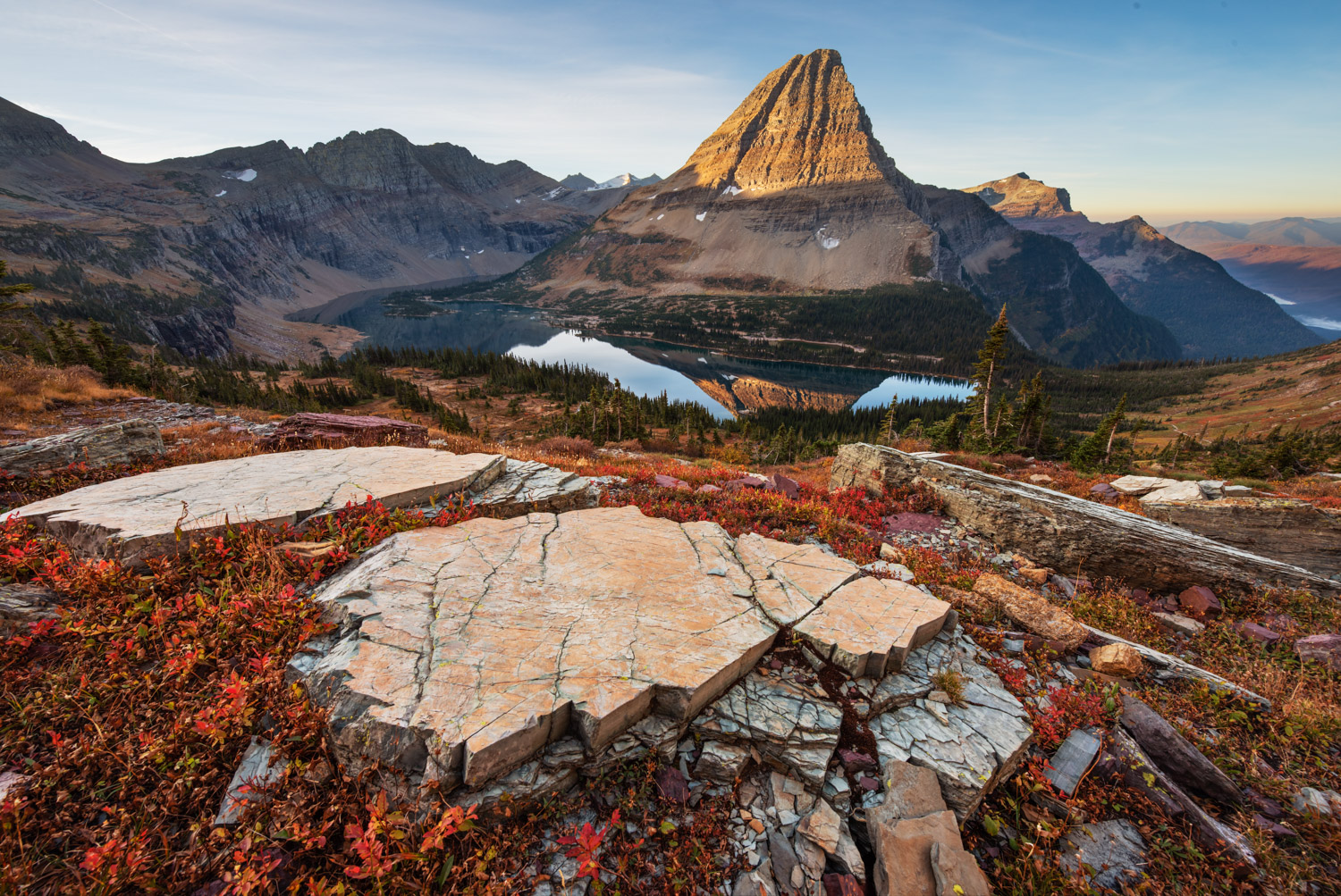 Slabs of granite crumble under mountain peaks above Hidden Lake in Glacier National Park while Bearhat Mountain greets the suns...